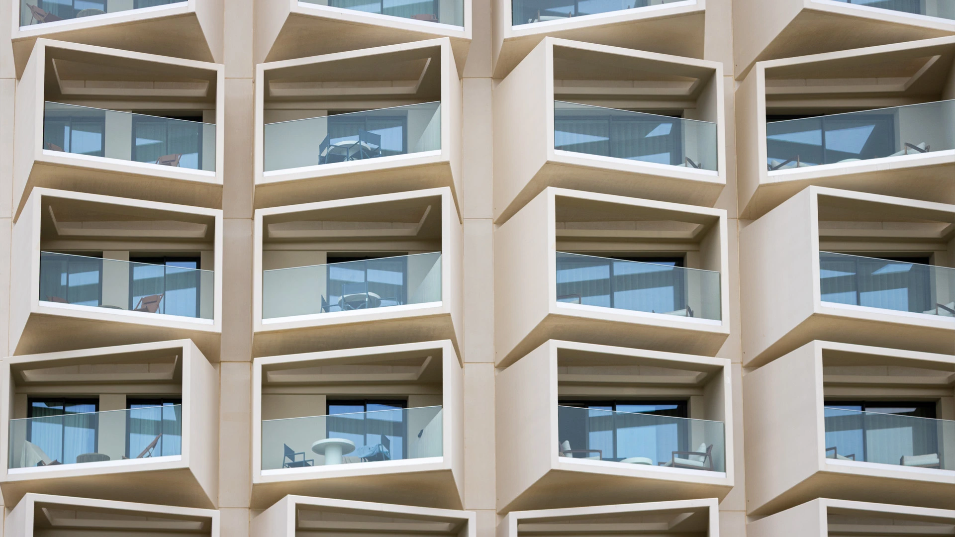 Fachada do Sun Cliffs Resort com caixilharia minimalista, evidenciando janelas minimalistas integradas em varandas de linhas geométricas e arquitetura contemporânea.